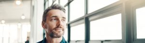 Man staring out of office windows