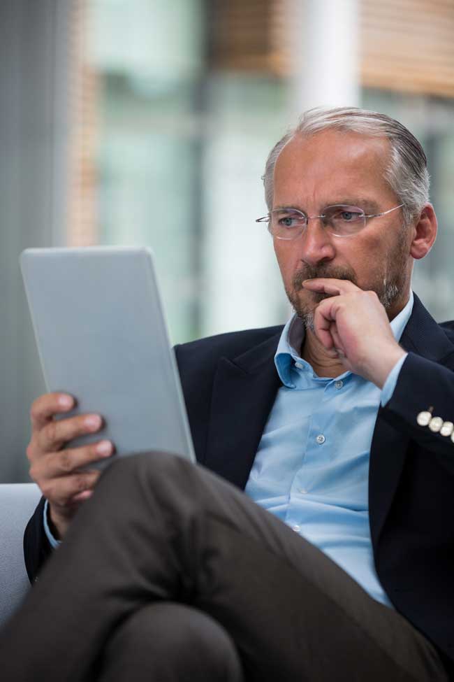 image of hopeful businessman on a tablet