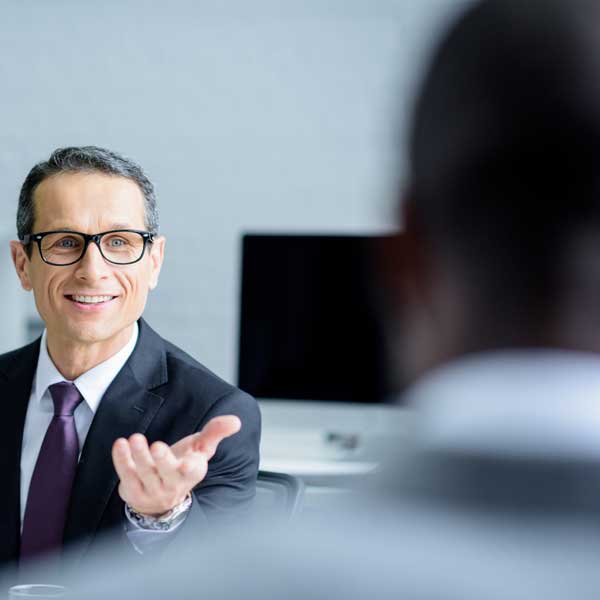selective-focus-of-smiling-600px man smiling withy hand out
