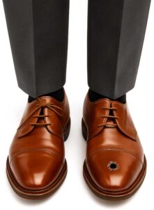 wingtip shoes with bullet hole