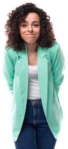 Woman with curly hair wearing a mint green blazer and white top, smiling softly at the camera.