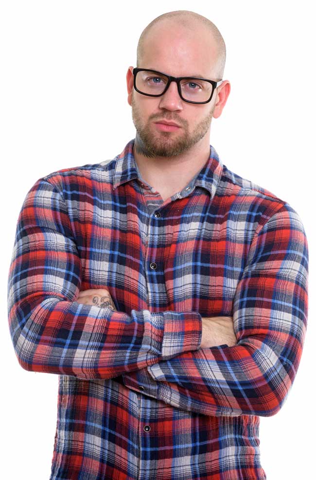 casually dressed professional with concerned expression and arms folded