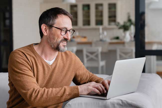 man-working-on-laptop-from-home-on-sofa