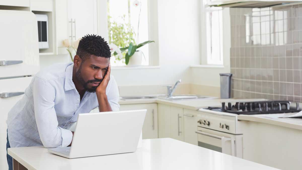 a mid-career professional (40s–50s) at a laptop, looking tired